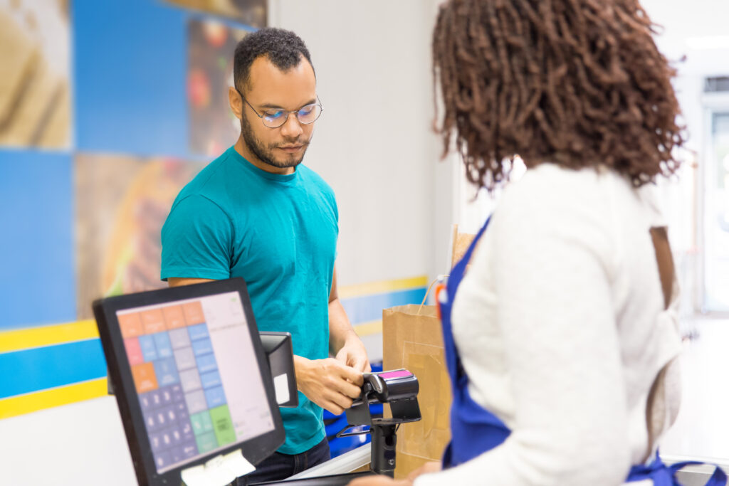 focused young man paying bill store scaled
